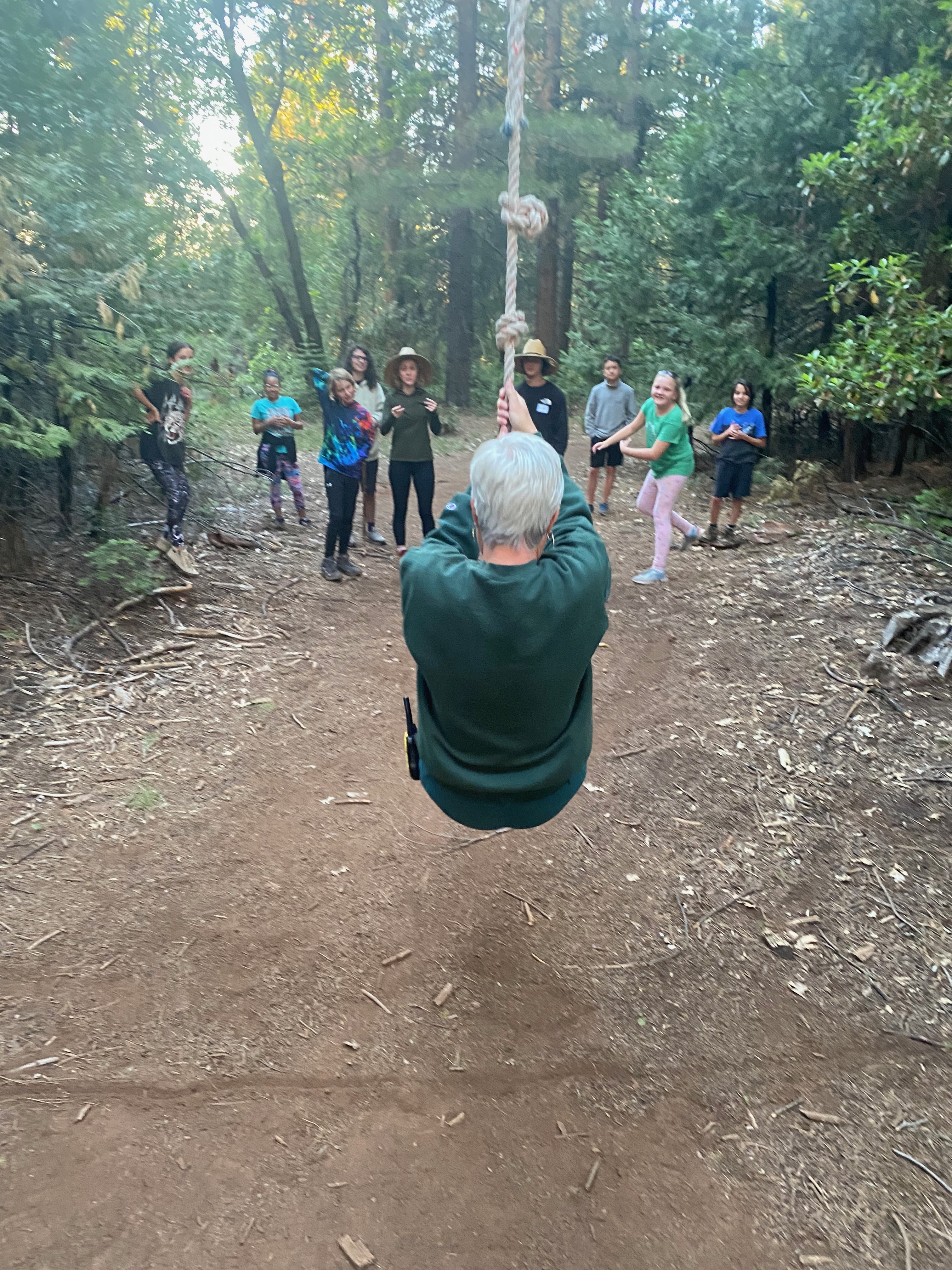 Counselor swinging on the ropes course